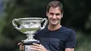 Petenis Swiss, Roger Federer tersenyum saat berpose dengan Piala Challenge Norman Brookes di Government House, Melbourne, Australia (29/1). Federer mengalahkan petenis Kroasia Marin Cilic 6-2, 6-7(5), 6-3, 3-6, 6-1. (AP Photo/Dita Alangkara)