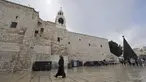 Seorang biarawan Kristen berjalan menjelang Natal di luar Gereja Kelahiran Yesus di kota Bethlehem, Tepi Barat pada 22 Desember 2022. Menjelang perayaan Natal, Kota Bethlehem sudah bersolek. Dekorasi liburan dan cerita kelahiran Yesus menghiasi kota itu. (AFP/Hazem Bader)