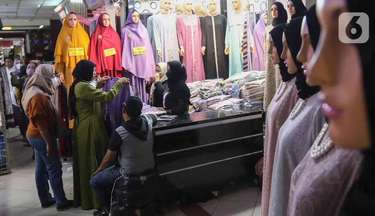 Calon pembeli memilih baju di Pasar Tanah Abang, Jakarta, (28/3/2022). Sepekan menjalang bulan suci Ramadan, Pasar Tanah Abang mulai dipadati pembeli yang hendak berbelanja untuk kebutuhan bulan puasa. (Liputan6.com/Herman Zakharia)