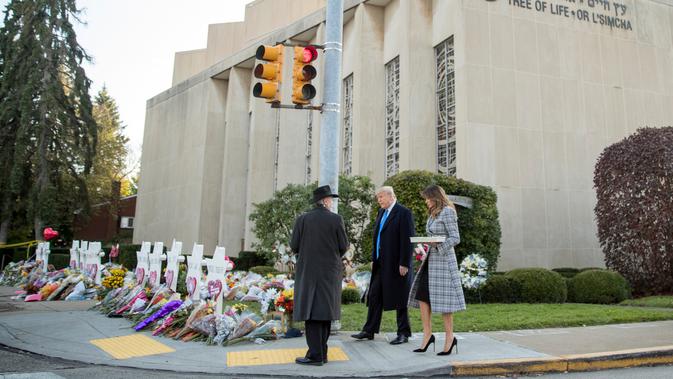 Rabbi Jeffrey Myers (kiri) mendampingi Presiden Donald Trump dan Melania Trump saat mengunjungi monumen peringatan penembakan maut di sinagog Tree of Life, Kota Pittsburgh, Pennsylvania, AS, Selasa (30/10). (AP Photo/Andrew Harnik)