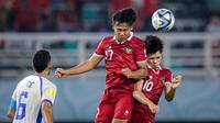 Dua pemain Timnas Indonesia U-17, Nabil Asyura (kiri) dan Ji Da Bin berusaha menyundul bola saat menghadapi Timnas Panama U-17 pada laga kedua Grup A Piala Dunia U-17 2023 di Stadion Gelora Bung Tomo (GBT), Surabaya, Senin (13/11/2023). (Bola.com/Bagaskara Lazuardi)