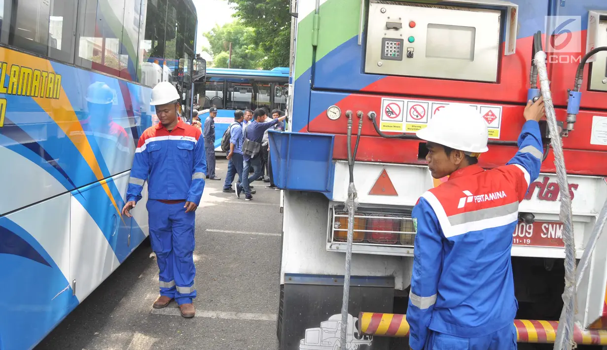 Petugas mempersiapkan selang gas untuk Bus BRT Trans Semarang di Pelataran Parkir Patra Jasa Semarang, Rabu (9/1). Sejumlah bus mulai beralih menggunakan Bahan Bakar Gas (BBG)  pada bus sedang (medium) . (Liputan6.com/Gholib)
