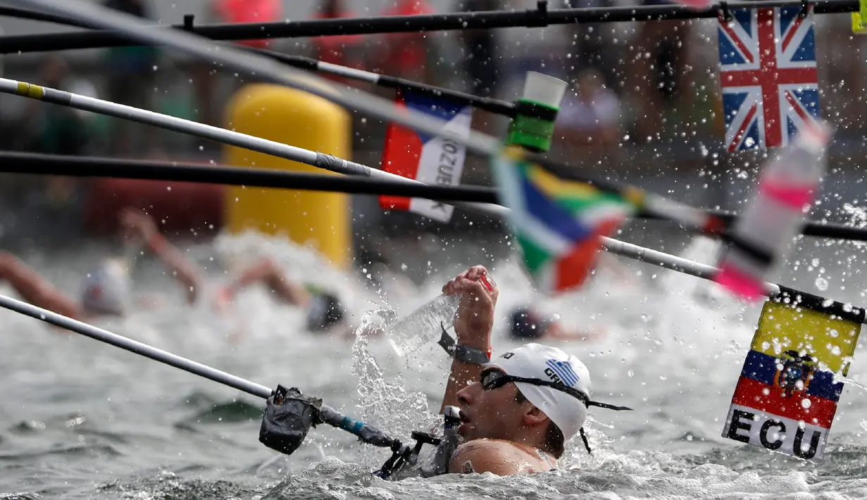 Perenang Yunani Athanasios Kynigakis meraih botol minuman saat berlaga dalam lomba renang air terbuka nomor 10 km putra di Kejuaraan Renang Dunia di Yeosu, Korea Selatan, Selasa (16/7/2019). (AP Photo/Mark Schiefelbein)