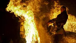 Seorang pria mengendarai kuda melintas kobaran api selama perayaan " Luminarias " di desa San Bartolome de Pinare, Spanyol, (16/1).  Tradisi sudah ada 500 tahun lalu di desa ini. (REUTERS / Susana Vera)