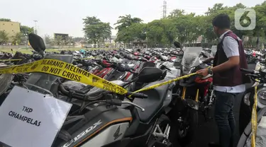 Personel Direktorat Tindak Pidana Umum Bareskrim Polri melakukan pemeriksaan barang bukti pengungkapan kasus tindak pidana fidusia atau penipuan dan penadahan kendaraan bermotor jaringan internasional di Lapangan SLog Polri, Jakarta Timur, Kamis (18/7/2024). (merdeka.com/Imam Buhori)