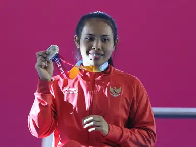 Atlet Para Powerlifting Indonesia, Ni Nengah Widiasih memperlihatkan medali perak Womens Up to 41.00kg Asian Para Games 2018 di Jakarta, Minggu (7/10). Ni Nengah Widiasih berhasil melakukan total angkatan 97 kg. (Liputan6.com/Helmi Fithriansyah)