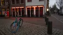 Sebuah sepeda parkir di luar jendela pekerja seks yang tutup di Red Light District di Amsterdam, Belanda pada Selasa (15/12/2020). Pemerintah Belanda menetapkan lockdown total untuk meredam virus corona COVID-19 selama 5 minggu dimulai pada periode Natal. (AP Photo/Peter Dejong)