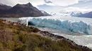 Wisatawan melihat fenomena langka runtuhnya dinding es raksasa dari Gletser Perito Moreno di Taman Nasional Los Glaciares, Argentina, Kamis (10/3). Siklus pecahnya es ini tidak teratur dan berulang secara alami di setiap frekuensi. (AFP PHOTO/Walter Diaz)