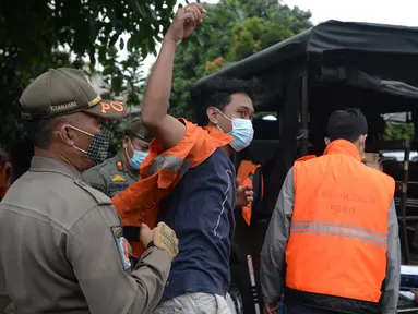 Warga yang terjaring razia protokol kesehatan COVID-19 mengenakan rompi di Kebon Nanas, Jakarta, Selasa (15/6/2021). Saat kasus positif Covid-19 di Jakarta meningkat, masih banyak warga yang belum menjalankan protokol kesehatan, salah satunya mengenakan masker. (merdeka.com/Imam Buhori)
