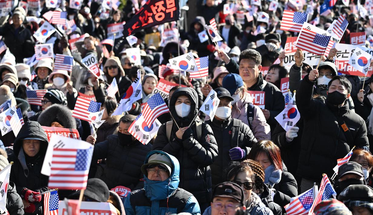 Dalam aksinya, mereka meneriakkan dukungan terhadap Presiden Yoon Suk Yeol sambil mengibarkan bendera Korea Selatan dan Amerika Serikat. (JUNG YEON-JE/AFP)
