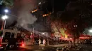 Petugas pemadam kebakaran berusaha memadamkan api yang melahap bangunan 26 lantai di Sao Paulo, Brasil, Selasa (1/5). Saksi mengatakan api menyebar dengan cepat dari salah satu lantai bawah dan membakar bangunan yang bersebelahan. (AP/Andre Penner)
