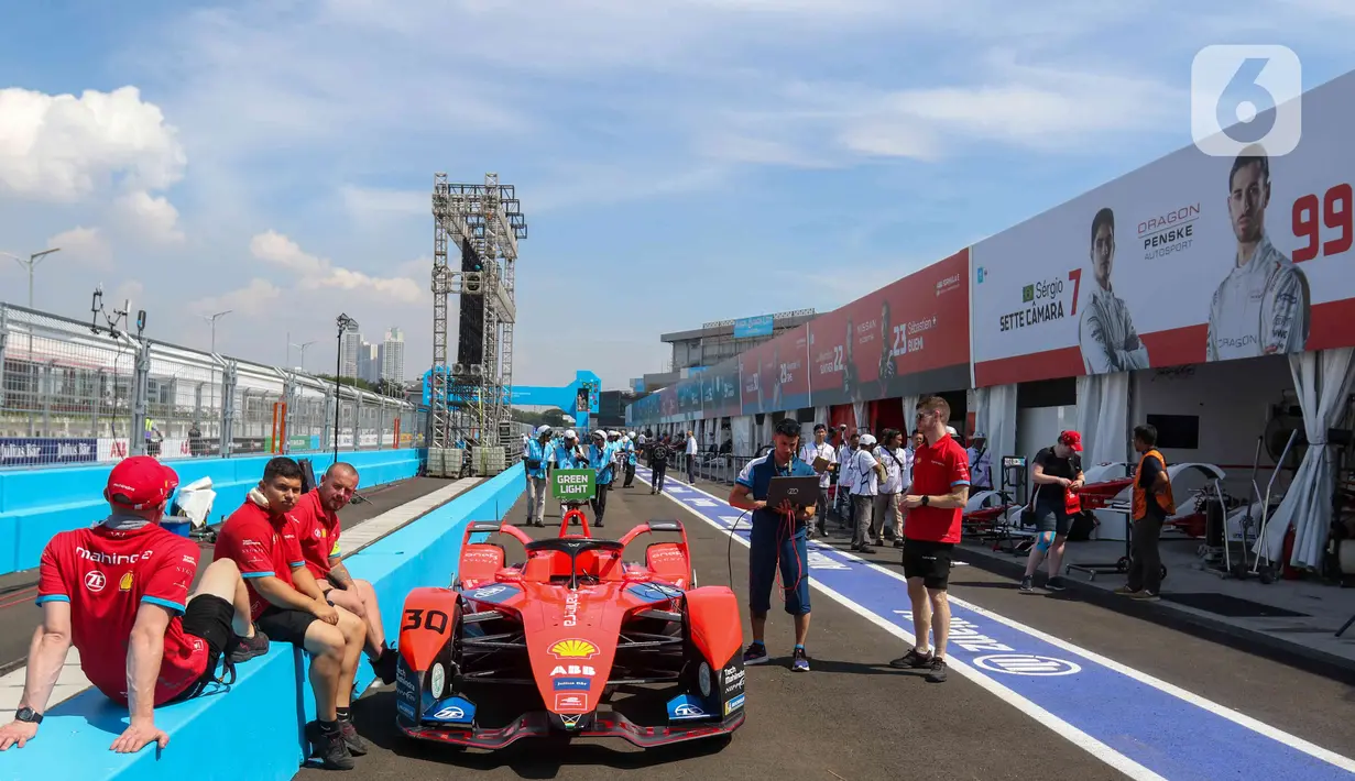 Kru tim peserta lomba balap melakukan persiapan mobil listrik Formula E  di pit Jakarta International E-Prix Circuit (JIEC), Jakarta, Jumat (3/6/2022). Menjelang pertandingan Formula E pada besok hari (4/6/2022) kru tim pembalap melakukan persiapan mobil listrik Formula E. (Liputan6.com/Herman Zakharia)