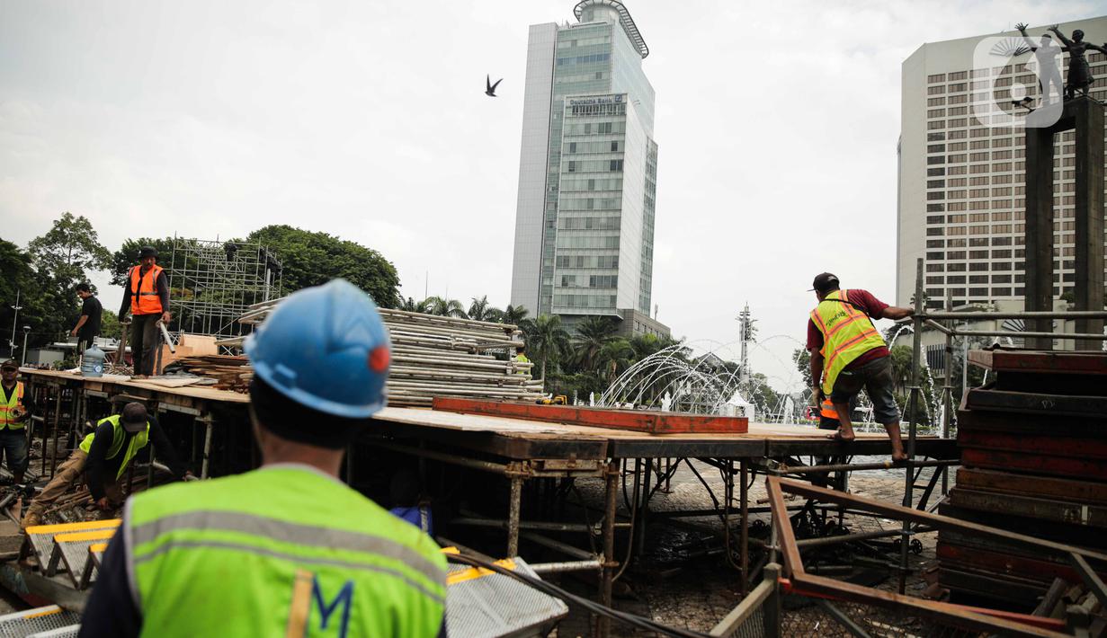 Pekerja menyelesaikan pembuatan panggung untuk acara malam tahun baru di sekitar kawasan Bundaran HI, Jakarta, Rabu (25/12/2019). Merayakan pergantian tahun, Pemprov DKI Jakarta menggelar sejumlah acara di sejumlah titik sepanjang Jalan Sudirman-MH Thamrin. (Liputan6.com/Faizal Fanani)