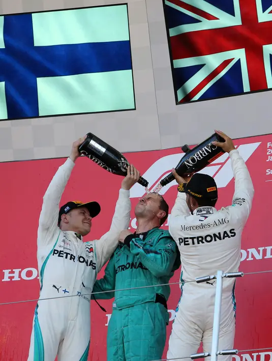 Pembalap Mercedes, Lewis Hamilton (kanan) merayakan kemenangannya di Formula Satu (F1) Grand Pix Jepang di Sirkuit Suzuka, Jepang (7/10). Hamilton berhasil mengalahkan rekan setimnya, Valtteri Bottas yang menempati posisi kedua. (AP Photo/Toru Takahashi)