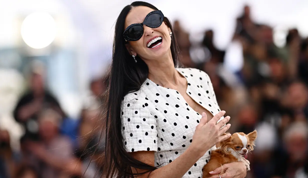 Demi Moore memeluk anjing kecilnya saat menghadiri photocall untuk film thriller horor terbarunya, Substance. (LOIC VENANCE / AFP)