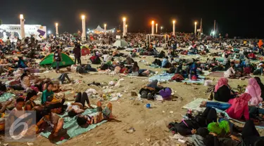 Sejumlah pengunjung tidur usai menyaksikan atraksi kembang api di Pantai Lagoon, Ancol, Jakarta, Minggu (1/1). Warga yang menghabiskan malam tahun baru di kawasan Ancol memilih untuk beristirahat hingga esok pagi. (Liputan6.com/Gempur M. Surya)