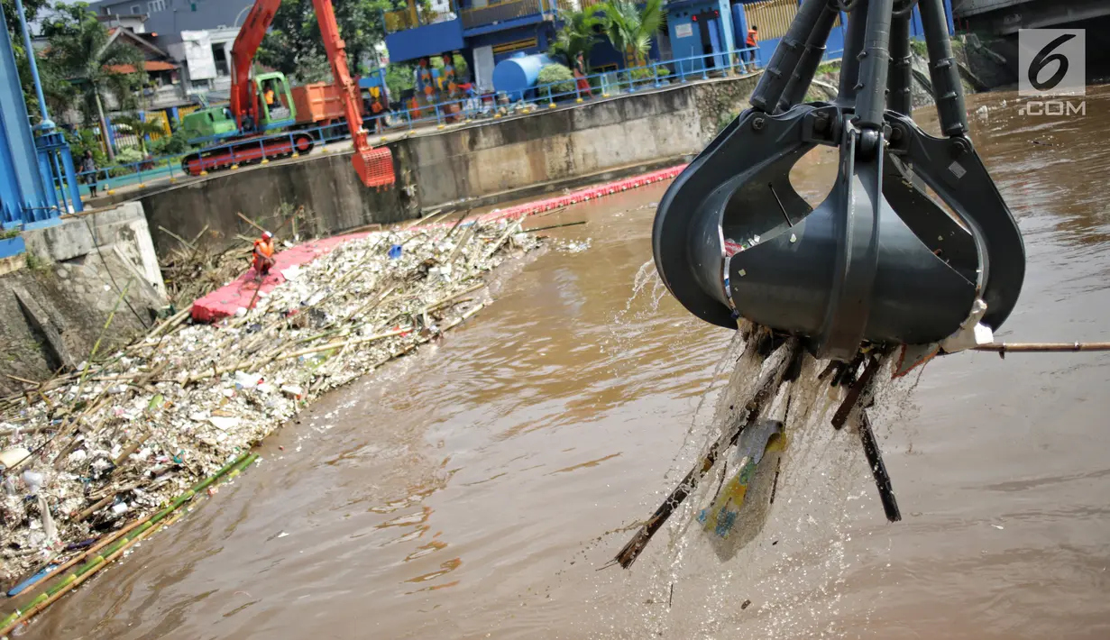 Alat berat (becko) beroperasi mengangkut sampah yang menumpuk di Pintu Air Manggarai, Jakarta, Selasa (26/2). Meningkatnya debit air Sungai Ciliwung menyebabkan terjadi penumpukan sampah di Pintu Air Manggarai. (Liputan6.com/Faizal Fanani)