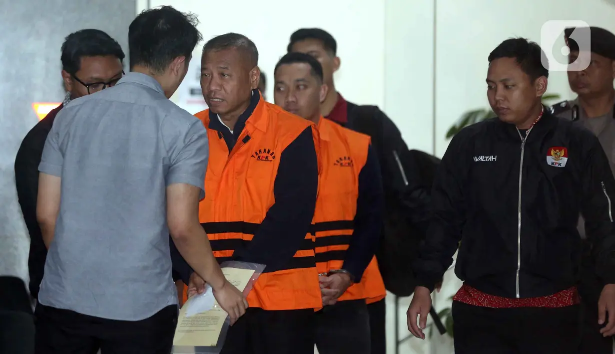 Dalam operasi tersebut, KPK mengamankan 16 orang, termasuk bupati dan sejumlah pejabat Pemerintah Kabupaten Tulungagung. Tampak dalam foto, Bupati Tulungagung, Gatut Sunu Wibowo (kedua kiri) dibawa petugas menuju mobil tahahan usai menjalani pemeriksaan intensif di Gedung Merah Putih Komisi Pemberantasan Korupsi (KPK), Jakarta, Minggu (12/4/2026) dini hari WIB. (Liputan6.com/Helmi Fitrhiansyah)
