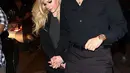 Rona bahagia terpancar dari wajah Avril saat terus digandeng oleh sang kekasih. Mereka pun juga tampak kompak dengan  outfit serba hitam yang dikenakannya saat itu. (doc. Daily Mail)