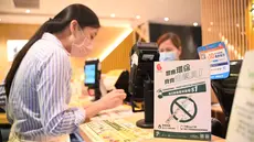 Sebuah tanda bertuliskan bahwa restoran tersebut tidak akan menyediakan peralatan makan plastik sekali pakai kepada pelanggan di Hong Kong, Senin (22/4/2024). (Peter PARKS / AFP)