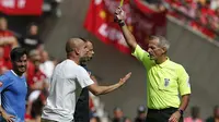 Pep Guardiola mendapat kartu kuning dari Martin Atkinson karena melakuan protes keras pada laga Community Shield 2019. (AFP/Ian Kington)