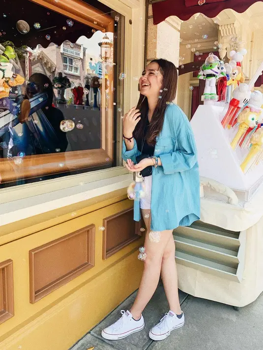 Tampil santai dengan kemeja biru, gaya Syifa Hadju saat di Disneyland Hongkong.