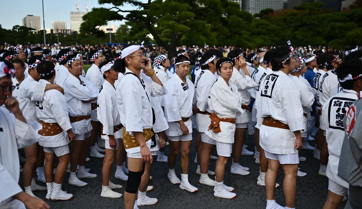 Peserta berkumpul selama perayaan nasional untuk menandai penobatan Kaisar Jepang Naruhito di depan Istana Kekaisaran di Tokyo (9/11/2019). Kaisar Naruhito menggantikan posisi ayahnya, Akihito yang menjadi kaisar pertama yang turun tahta. (AFP Photo/Charly Triballeau)