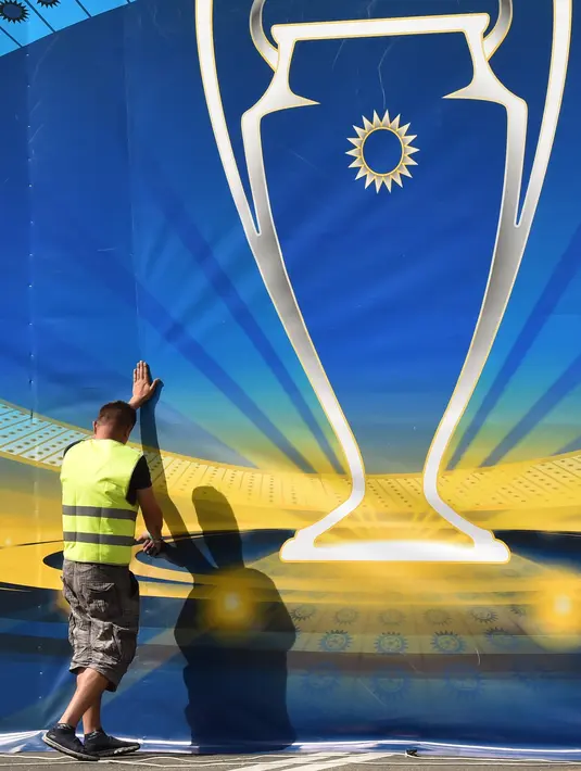 Seorang pekerja memasang dekorasi menjelang final Liga Champions antara Real Madrid dan Liverpool FC di Kiev, Ukraina, Senin (21/5). Final Liga Champions akan berlangsung pada 26 Mei 2018. (Sergei SUPINSKY/AFP)
