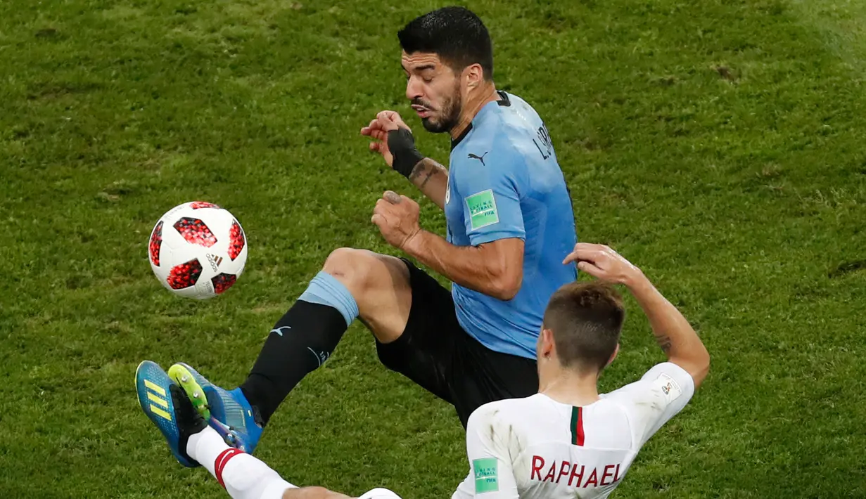 Penyerang Uruguay, Luis Suarez berebut bola dengan bek Portugal Raphael Guerreiro saat bertanding pada babak 16 besar Piala Dunia 2018 di Stadion Fisht, Sochi, Rusia (30/6). Uruguay menang tipis atas Portugal 2-1. (AP Photo/Darko Vojinovic)