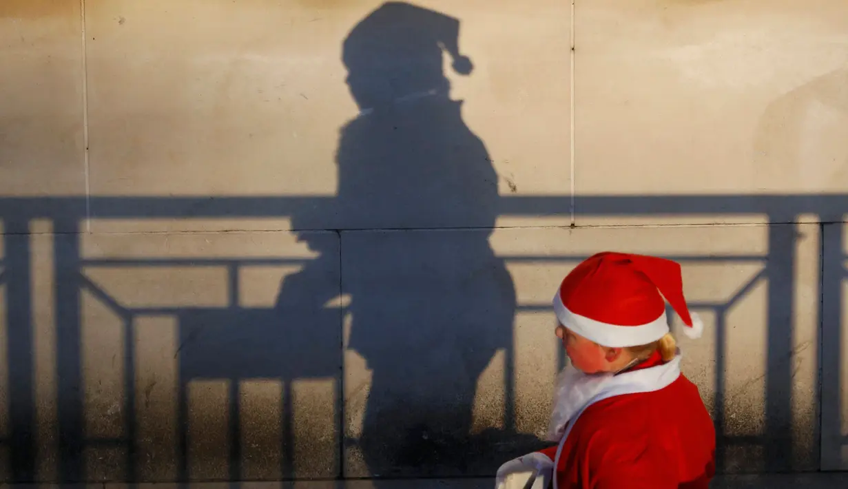 Seorang wanita berpakaian Santa Claus bersiap mengikuti balap lari Santa Dash di Liverpool, Inggris, Minggu (4/12). Lebih dari 8.000 orang diperkirakan mengikuti acara lari 5km Santa Dash yang diselenggarakan tiap tahun tersebut. (Reuters/Phil Noble)