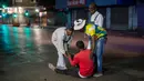 Orang-orang membantu seorang pria yang jatuh setelah dikejar polisi karena melanggar lockdown di pusat kota Johannesburg, Afrika Selatan, Jumat (27/3/2020). (AP Photo/Jerome Delay)
