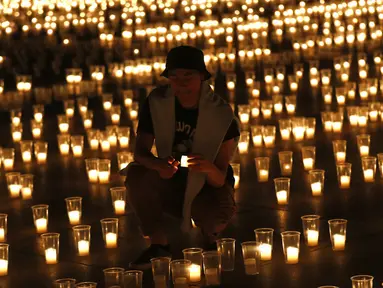 Seorang pria menyalakan lilin untuk memperingati para korban pandemi virus corona COVD-19 di Kastil Praha, Praha, Republik Ceko, Senin (10/5/2021). Republik Ceko melonggarkan pembatasan terkait COVID-19 secara besar-besaran kendati hampir 30 ribu orang telah meninggal. (AP Photo/Petr David Josek)