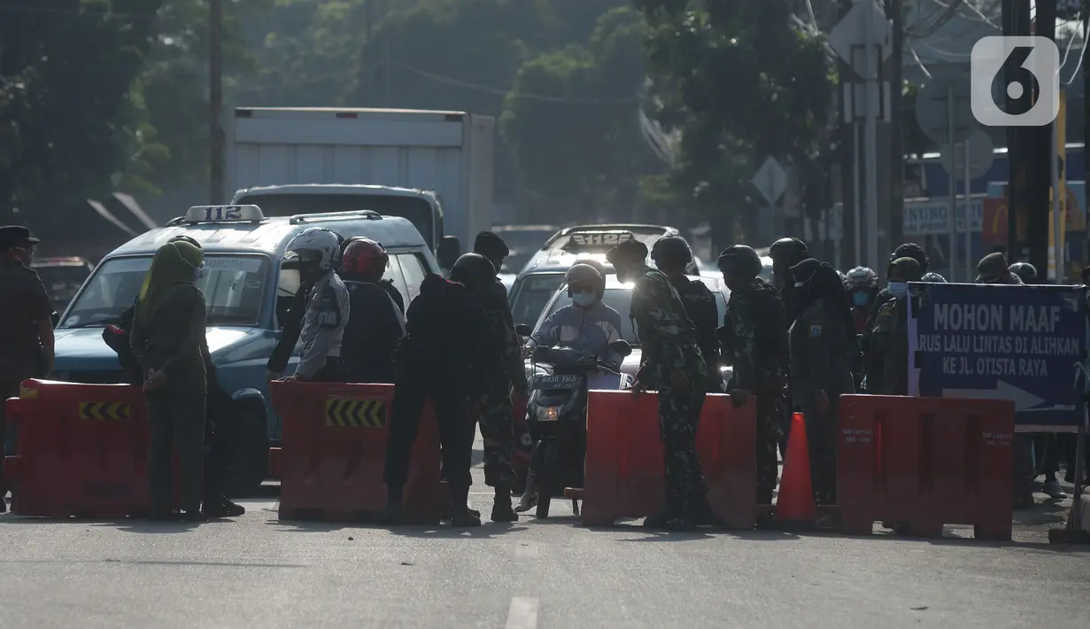 Petugas gabungan memeriksa sejumlah pengendara sepeda motor di pos penyekatan di Jalan Raya Bogor, Jakarta Timur, Selasa (6/7/2021). Petugas Gabungan Polri dan TNI menyiapkan kendaraan taktis untuk membantu penyekatan selama PPKM Darurat Jawa - Bali. (merdeka.com/Imam Buhori)