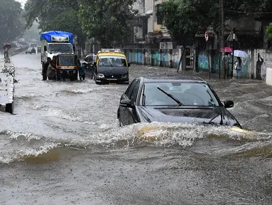 Sejumlah kendaraan melintasi banjir setelah hujan lebat di Mumbai, India (9/7). Mumbai dan daerah pinggiran lainnya telah mengalami hujan lebat semalaman yang mengakibatkan banjir. (AFP Photo/Indranil Mukherjee)