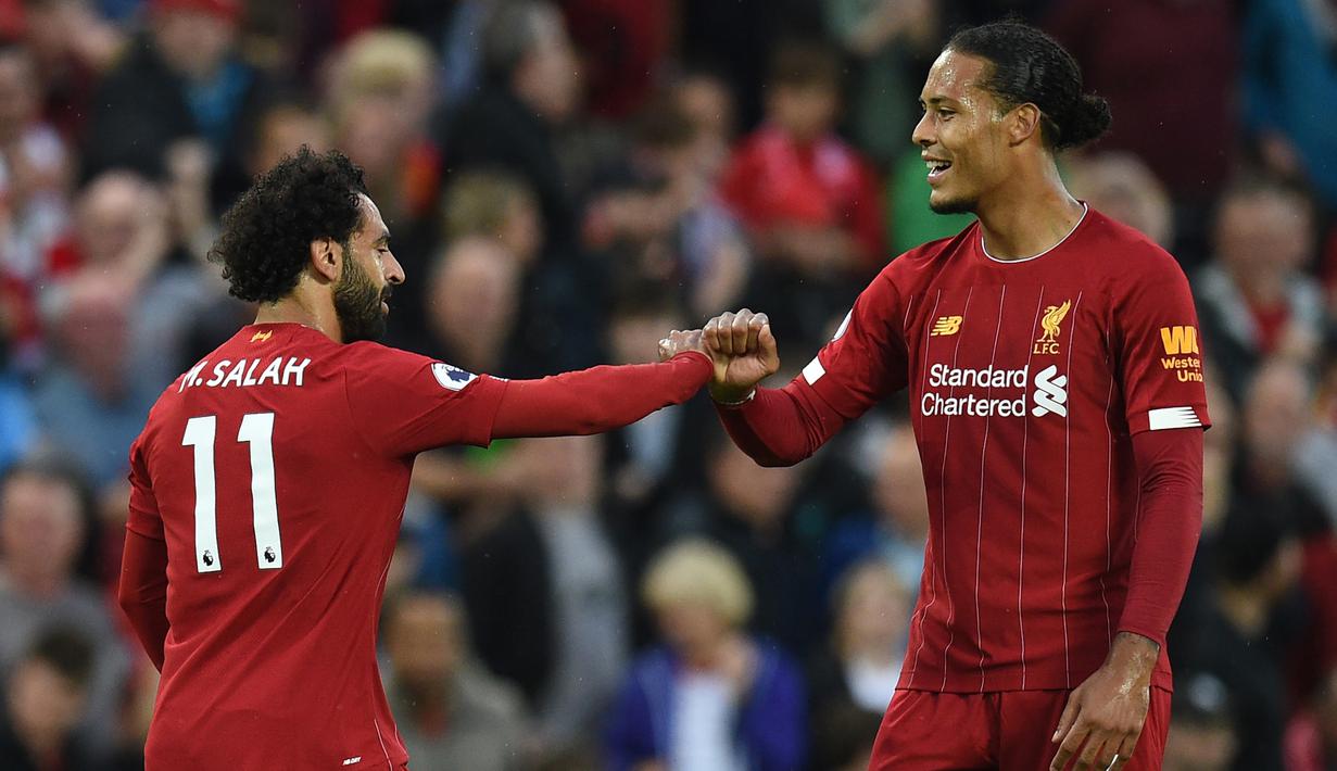 Pemain Liverpool, Mohamed Salah, merayakan gol yang dicetak Virgil Van Dijk ke gawang Norwich pada laga Premier League di Stadion Anfield, Liverpool, Jumat (9/8). Liverpool menang 4-1 atas Norwich. (AFP/Oli Scarff)
