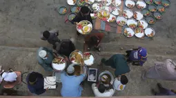 Relawan mengatur makanan untuk warga saat berbuka puasa bersama selama bulan suci Ramadan di Karachi, Pakistan, Selasa (12/5/2020). Warga berbuka puasa bersama setelah pemerintah melonggarkan lockdown terkait pandemi virus corona COVID-19. (AP Photo/Fareed Khan)