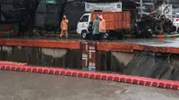 Sejumlah petugas memeriksa ketinggian air Pintu Air Manggarai, Jakarta, Senin (5/2). Warga di sekitaran Sungai Ciliwung diimbau untuk terus waspada akan tingginya limpahan air. (Liputan6.com/Faizal Fanani)