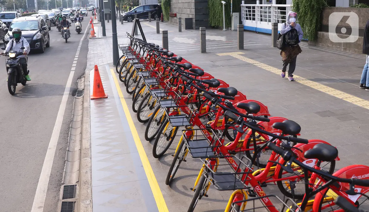 Pejalan kaki melintas di dekat deretan sepeda untuk layanan bike sharing atau penyewaan sepeda di Kawasan Jakarta, Jumat (3/7/2020). Layanan bike sharing yang bertujuan untuk mengurangi penggunaan kendaraan bermotor ini terbagi dalam 6 titik lokasi di Jakarta. (Liputan6.com/Angga Yuniar)