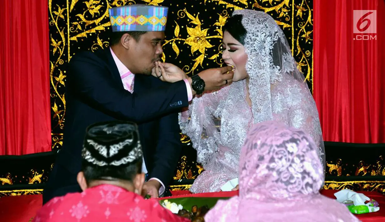 Putri Presiden Joko Widodo, Kahiyang Ayu dan Muhammad Bobby Afif Nasution saling menyuapi saat prosesi Mangalehan Marga, Boru Siregar, di rumah paman Bobby di Medan, Selasa (21/11). (Liputan6.com/Pool/Media Center)