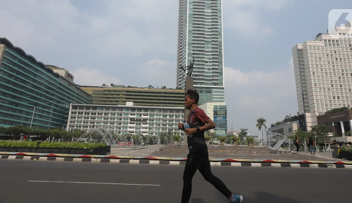 Seorang pria berolahraga di kawasan Bundaran HI, Jakarta, Minggu (20/10/2019). Car Free Day (CFD) ditiadakan Minggu (20/10) ini dalam rangka pelantikan Presiden dan Wapres periode 2019-2024, Joko Widodo dan Ma'aruf Amin di Kompleks Parlemen, Senayan, Jakarta. (Liputan6.com/Herman Zakharia)