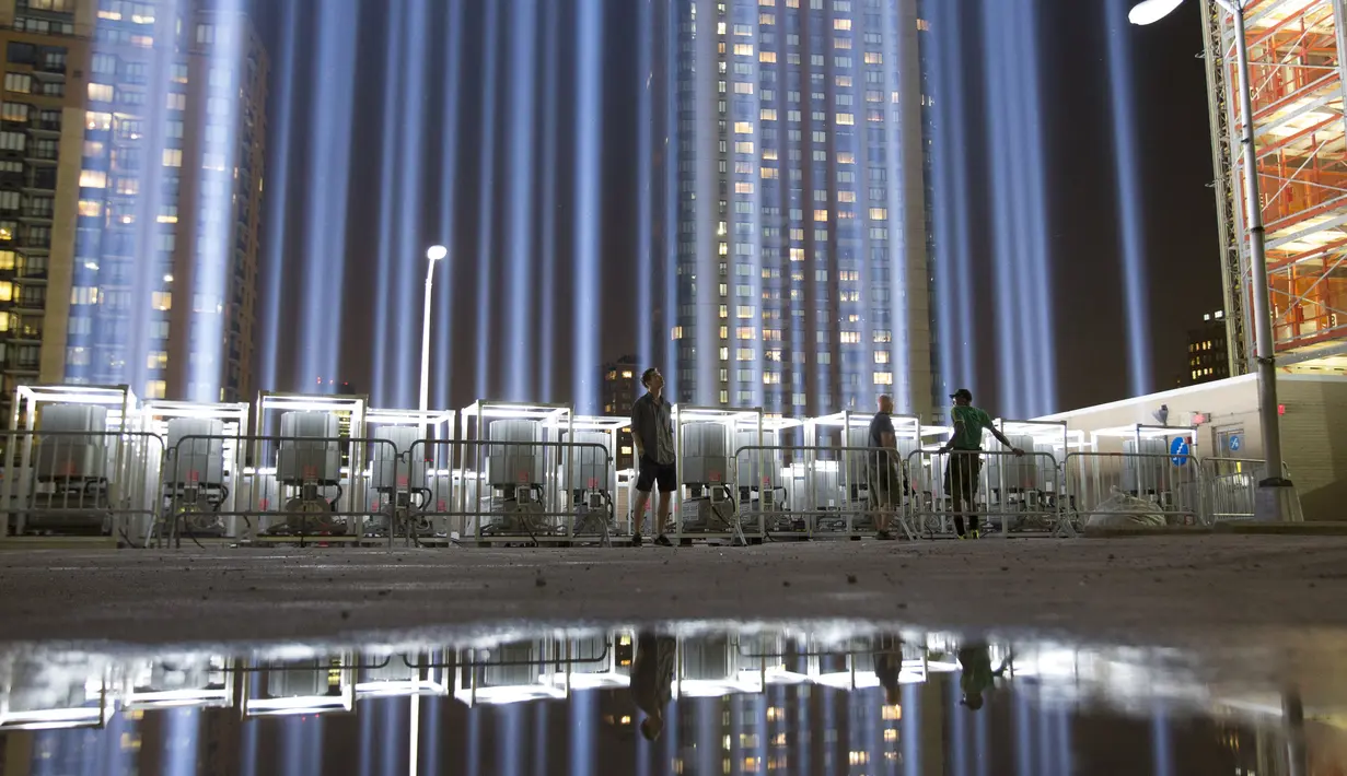 Pengunjung menikmati keindahan lampu sorot di World Trade Center (WTC) dipancarkan ke langit kota New York, AS, (9/9/2015). Acara dinamakan Tribute in Light memperingati 14 tahun tragedi terorisme 11 September di Amerika Serikat. (REUTERS/Andrew Kelly)