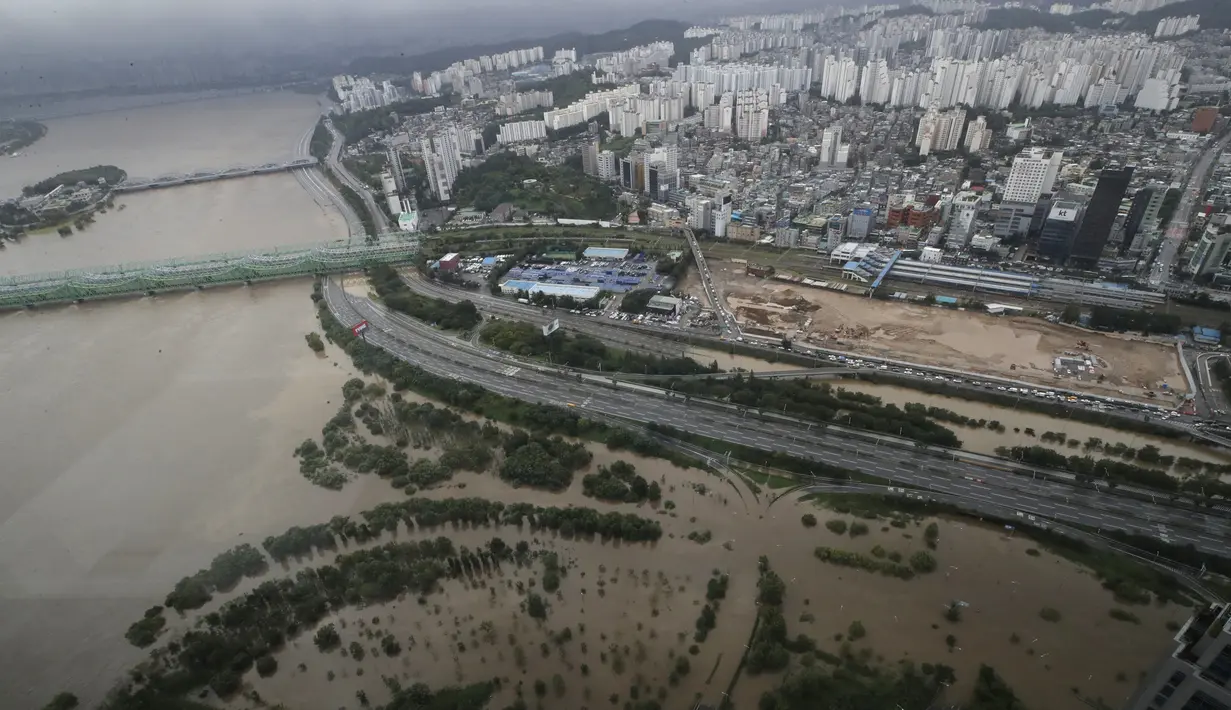 Sebagian jalan utama dan taman di dekat Sungai Han terendam banjir akibat hujan lebat di Seoul, Korea Selatan, Kamis (6/8/2020). Hujan lebat terus mengguyur Korea Selatan, mendorong pihak berwenang untuk menutup sebagian jalan raya dan mengeluarkan peringatan banjir. (AP Photo/Lee Jin-man)