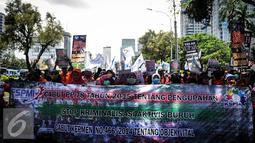 Ribuan buruh membentangkan spanduk berjalan menuju Istana Negara, Jakarta, Kamis (29/9). Dalam aksinya mereka menolak Tax Amnesty serta menaikan upah minumum provinsi (UMP) sebesar Rp650 ribu per bulan. (Liputan6.com/Faizal Fanani)