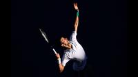 Petenis peringkat satu dunia, Novak Djokovic melakukan servis kearah Frances Tiafoe dalam ajang Australian Open. Novak Djokovic memenangkan perlombaan tersebut dengan susah payah. (Foto: AFP/David Gray)