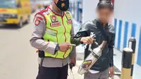 Seorang petugas kepolisian resort Garut, Jawa Barat akhirnya mengamankan knalpot bising yang dimiliki seorang pemotor. (Liputan6.com/Jayadi Supriadin)