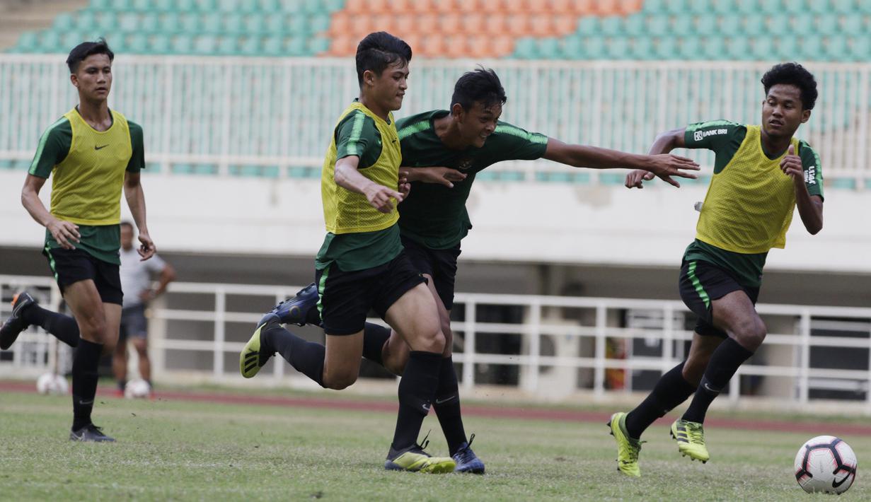 Para pemain Timnas Indonesia U-19 berebut bola saat latihan di Stadion Pakansari, Bogor, Senin (30/9). Latihan ini merupakan persiapan jelang Piala AFF U-19 di Vietnam. (Bola.com/Vitalis Yogi Trisna)