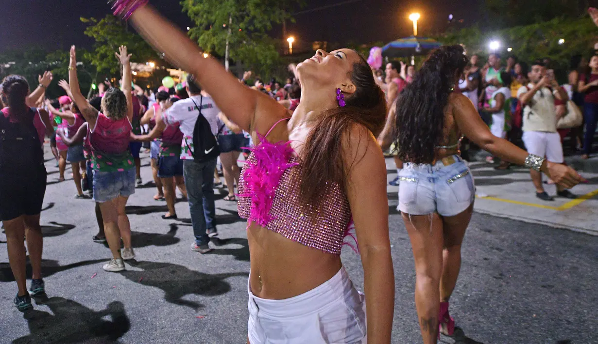 Dua wanita menari selama sesi latihan oleh sekolah samba Mangueira di Rio de Janeiro, Brasil (21/2). Karnaval Rio de Janeiro akan berlangsung dari 2 Maret hingga 9 Maret 2019. (AFP Photo/Carl De Souza)