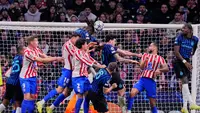 Pemain Atletico Madrid, Jose Gimenez dan Marc Pubill melompat berebut bola dengan para pemain Inter Milan pada laga Liga Champions di Madrid. (AP Photo/Manu Fernandez)