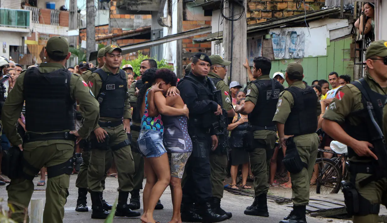 Warga menangis usai kerabatnya menjadi korban penembakan massal di sebuah bar di kota Belm, negara bagian utara Par, Brazil (19/5). Hampir semua korban tewas mengalami luka tembak di bagian kepala, lapor situs web G1. (Claudio Pinheiro/Agencia Panamazonica/AFP)