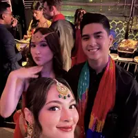 Laura Moane hadir mengenakan busana ala Bollywood warna merah lengkap dengan hiasan kepala. Ia hadir bersama kekasih, Al Ghazali yang dibalut baju hitam lengkap dengan selendang colorful. [@joleneemarie]